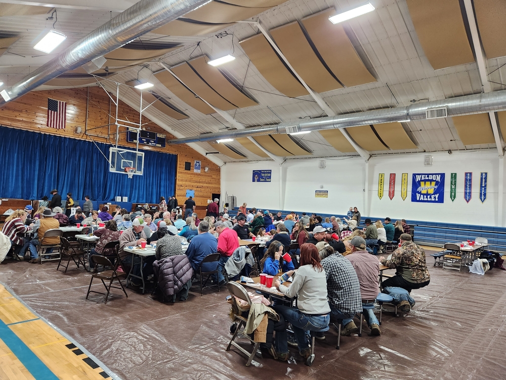 Gym full of people sitting at tables.